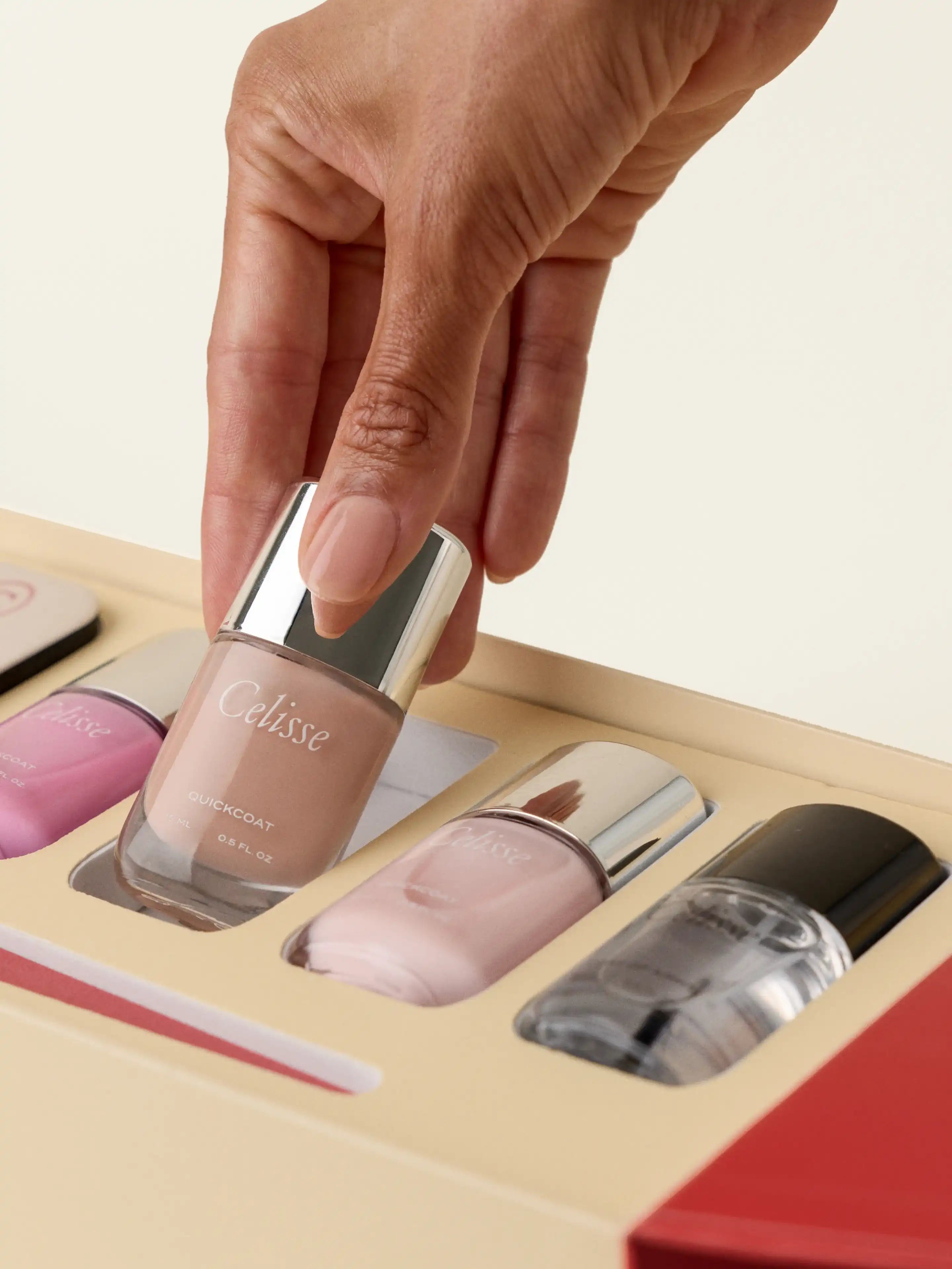 Celisse nail polish set with a hand picking up a bottle